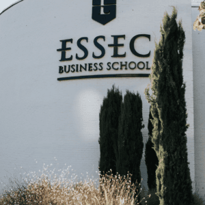 Façade blanche incurvée de lESSEC, école de commerce, logo et végétation.