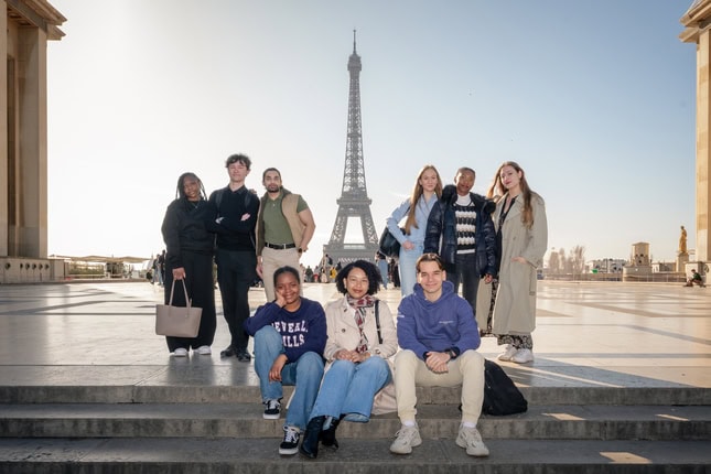 Groupe damis assis devant la Tour Eiffel à Paris, photo de voyage matinale.
