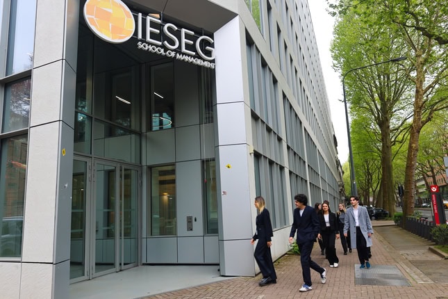 Entrée IÉSEG, école de management moderne, façade vitrée, étudiants arrivant.