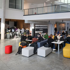 Espace commun étudiant moderne et lumineux avec banquettes modulables pour travail collaboratif.