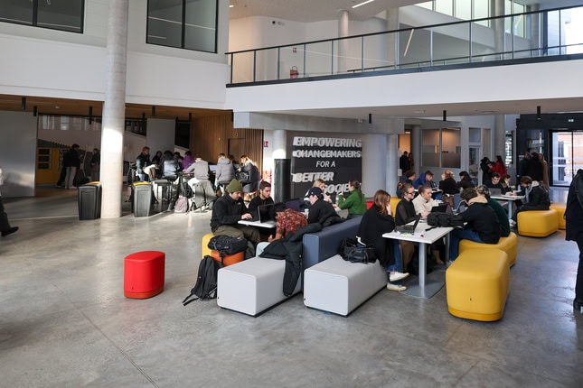 Espace commun étudiant moderne et lumineux avec banquettes modulables pour travail collaboratif.