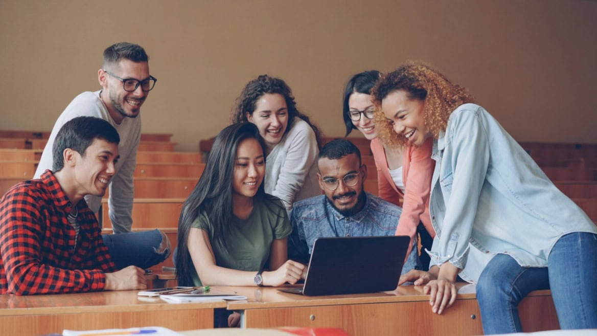 Étudiants réunis autour dun ordinateur portable, projet collaboratif en salle de classe.