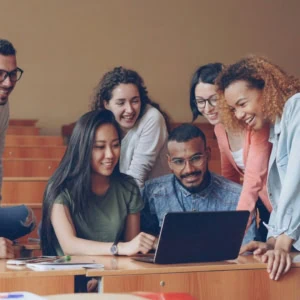Étudiants réunis autour dun ordinateur portable, projet collaboratif en salle de classe.