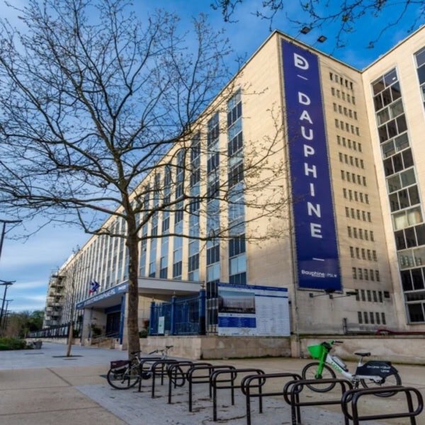 Façade de luniversité Dauphine, rue calme, vélos et ciel bleu.