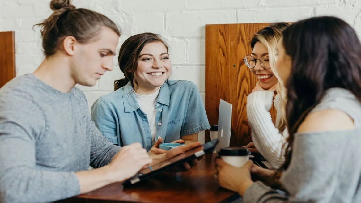 Groupe détudiants au café, travail collaboratif avec ordinateur et tablette.
