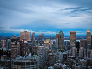 Panorama urbain au crépuscule : ligne dhorizon de gratte-ciels, ville dense et ciel nuageux.