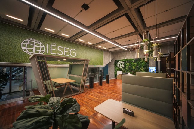 Lobby IESEG contemporain avec mur végétal, réception, banquettes et tourniquets.