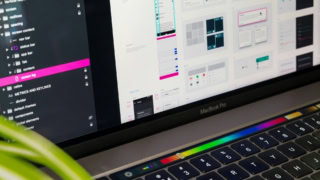 MacBook Pro écran montrant maquettes dinterface utilisateur et design, Touch Bar visible.