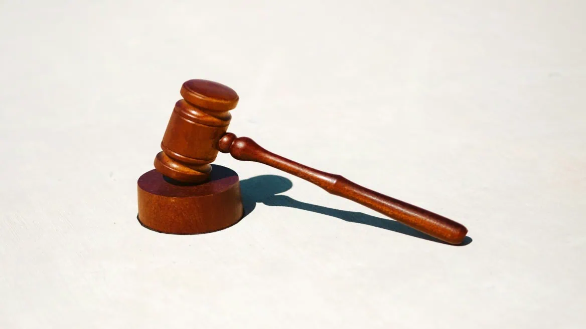 Marteau de juge en bois sur bloc, symbole de justice et décision.