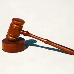 Marteau de juge en bois sur bloc, symbole de justice et décision.