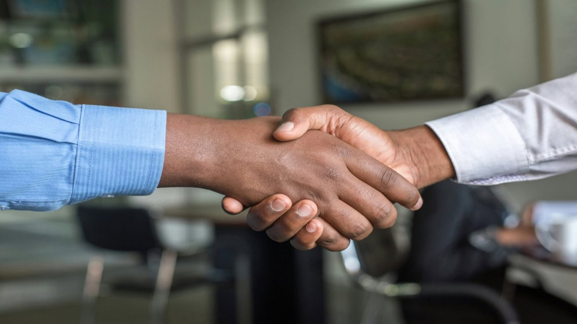 Poignée de main professionnelle au bureau, accord commercial et confiance entre collaborateurs.
