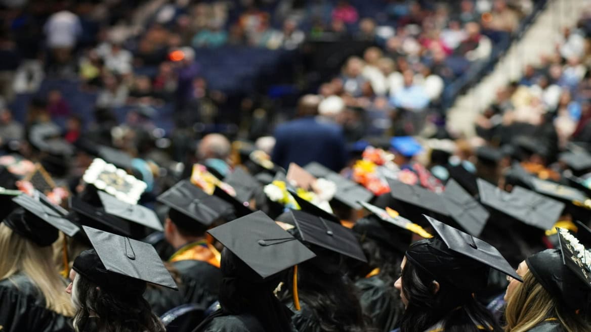 Remise des diplômes : foule détudiants en toques noires lors dune cérémonie.