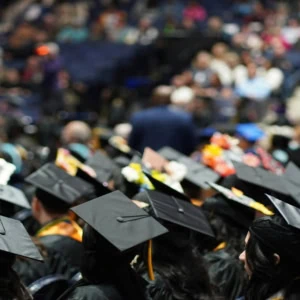Remise des diplômes : foule détudiants en toques noires lors dune cérémonie.