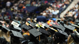 Remise des diplômes : foule détudiants en toques noires lors dune cérémonie.