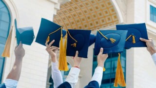 Remise de diplômes à luniversité, chapeaux bleu marine levés devant bâtiment classique.