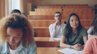 Salle de cours en bois, lumière naturelle, étudiants concentrés prenant des notes.