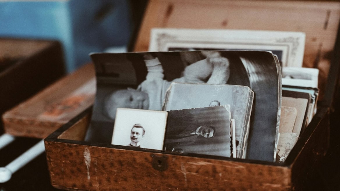 Boîte en bois remplie de photos anciennes noir et blanc, souvenirs familiaux vintage.