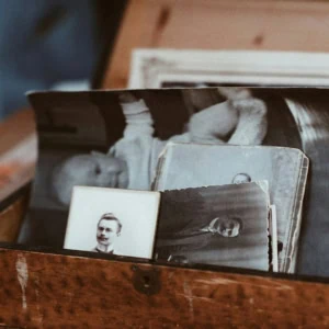 Boîte en bois remplie de photos anciennes noir et blanc, souvenirs familiaux vintage.