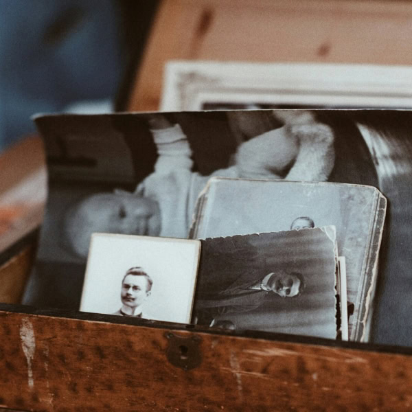 Boîte en bois remplie de photos anciennes noir et blanc, souvenirs familiaux vintage.
