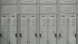 Casiers métalliques numérotés 19 à 26 dans un vestiaire scolaire, serrures visibles.