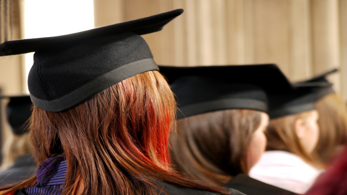 Chapeaux de diplômés noirs alignés sur cheveux bruns lors dune cérémonie de remise de diplômes.