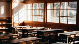 Classe vintage vide baignée de lumière naturelle, bureaux en bois et grandes fenêtres à carreaux.