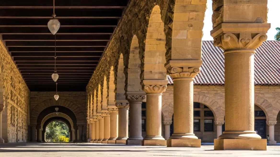 Colonnade en pierre, arcades et colonnes, perspective profonde, lumière solaire et ombres.