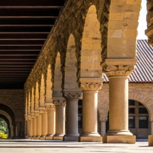 Colonnade en pierre, arcades et colonnes, perspective profonde, lumière solaire et ombres.