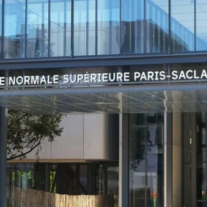 Entrée de lÉcole normale supérieure Paris‑Saclay : façade vitrée moderne et marquise métallique.