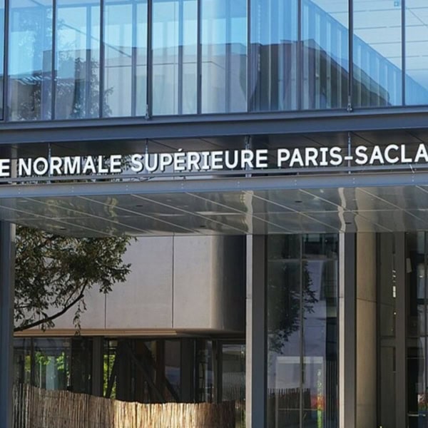 Entrée de lÉcole normale supérieure Paris‑Saclay : façade vitrée moderne et marquise métallique.