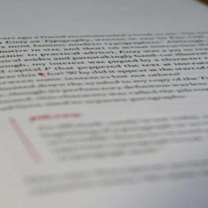 Gros plan dune page de préface typographique avec lettrine rouge, papier texturé, faible profondeur de champ.