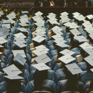 Vue plongeante de diplômés en toques et robes bleues alignés lors dune remise de diplômes.