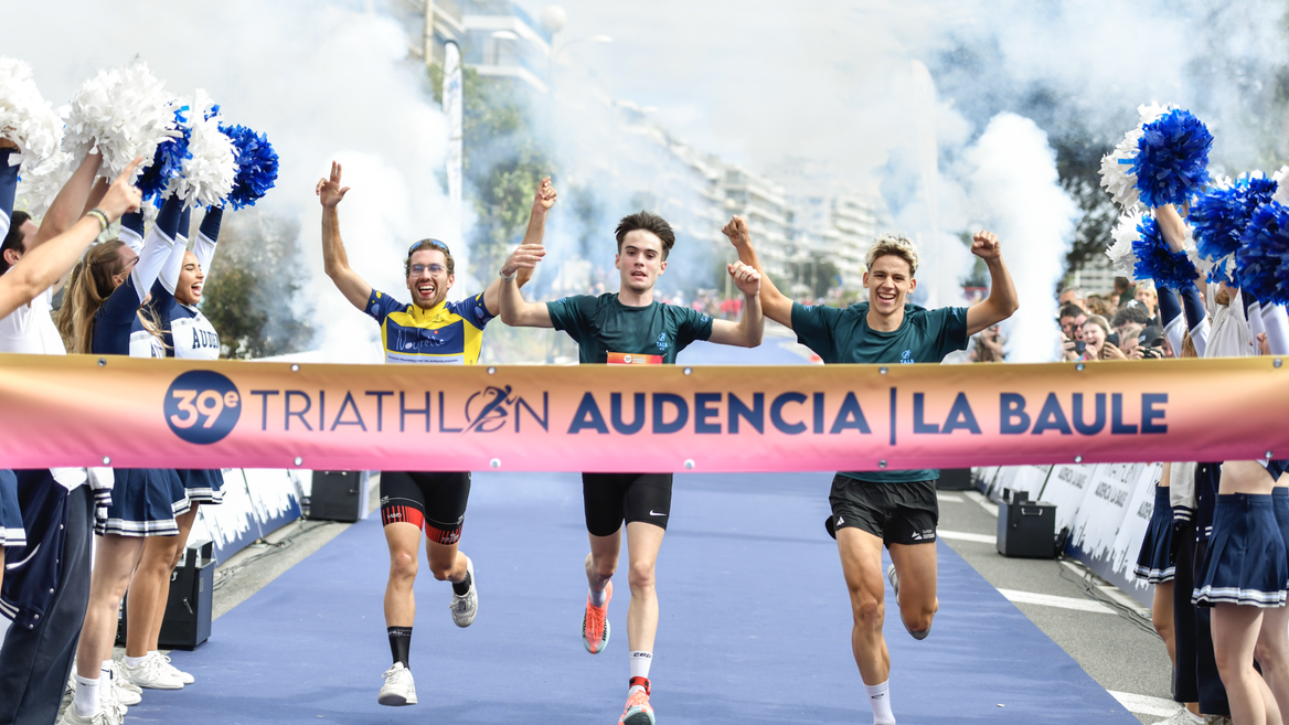 Triathlon La Baule : arrivée festive de coureurs sous banderole et fumée.