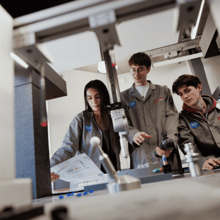 Étudiants en atelier robotique ECAM LaSalle testant et ajustant un robot en laboratoire.