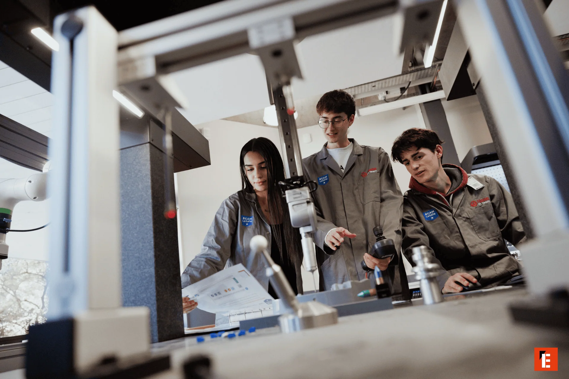 Étudiants en atelier robotique ECAM LaSalle testant et ajustant un robot en laboratoire.