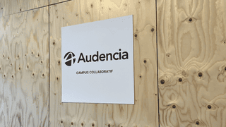 Panneau blanc Audencia avec logo et mention « Campus collaboratif » sur bois brut.