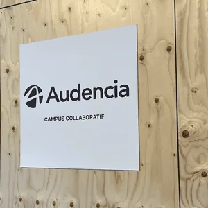 Panneau blanc Audencia avec logo et mention « Campus collaboratif » sur bois brut.