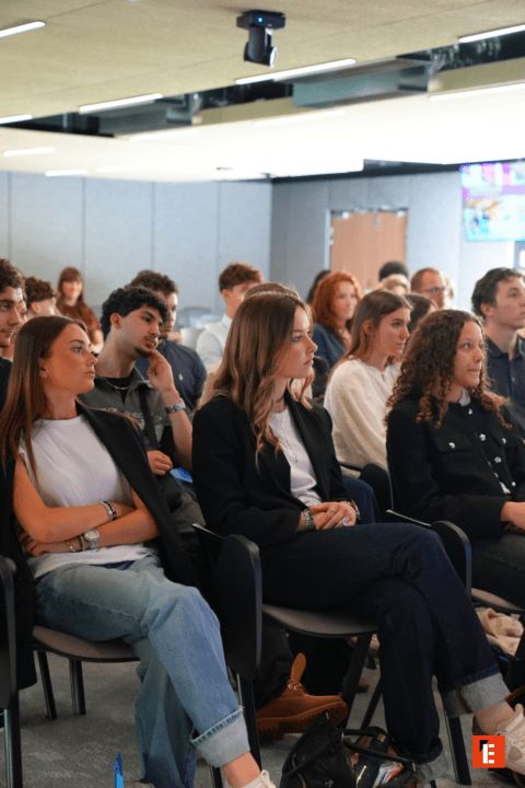 Audience attentive lors dune conférence professionnelle en salle moderne.