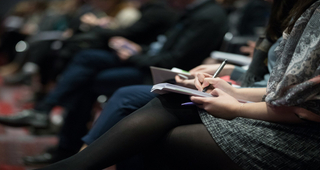 Prise de notes en auditoire pendant une conférence ou un séminaire.
