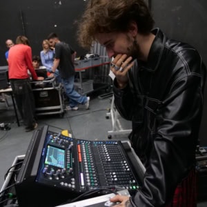 Ingénieur du son ajustant une console de mixage numérique en studio de répétition.