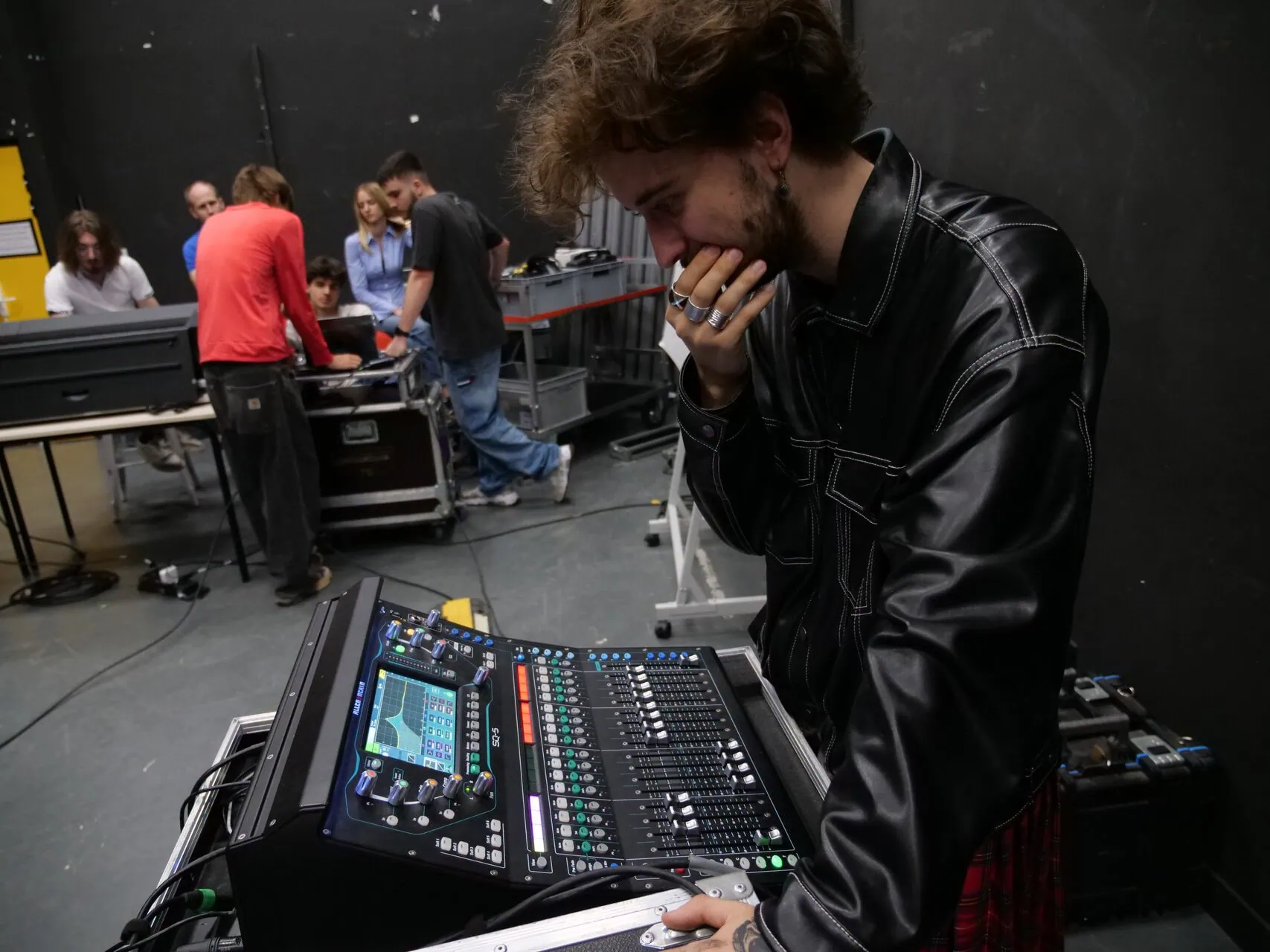 Ingénieur du son ajustant une console de mixage numérique en studio de répétition.