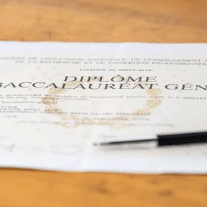 Diplôme du baccalauréat général officiel posé sur bois avec stylo, certificat académique élégant.