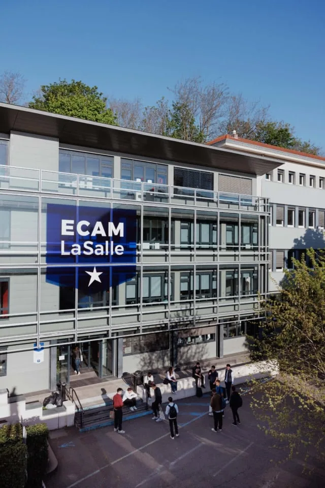 Façade vitrée du campus ECAM LaSalle avec étudiants devant lentrée.