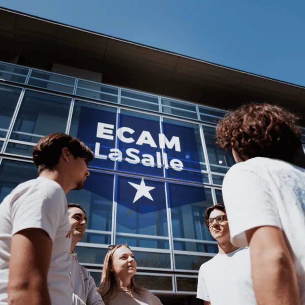 Étudiants devant façade vitrée ECAM LaSalle sur campus, ciel bleu.