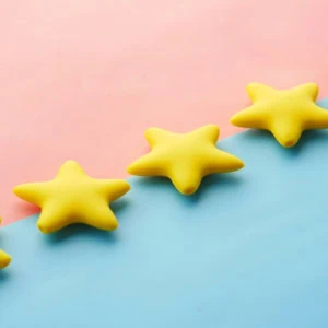 Cinq étoiles jaunes en diagonale sur fond pastel rose et bleu, style minimaliste et ludique.