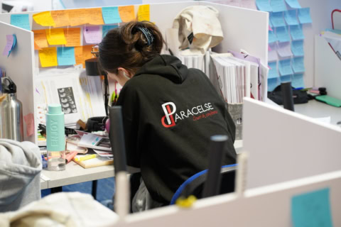 Étudiant concentré au bureau, post‑it colorés, notes, cahiers et écouteurs.