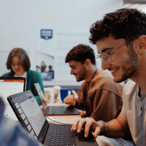 Étudiants travaillant en groupe sur ordinateurs portables dans un espace détude lumineux.