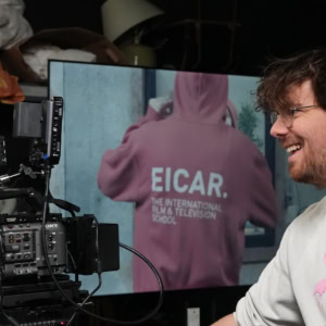 Caméra professionnelle et matériel de studio, homme souriant en tournage.