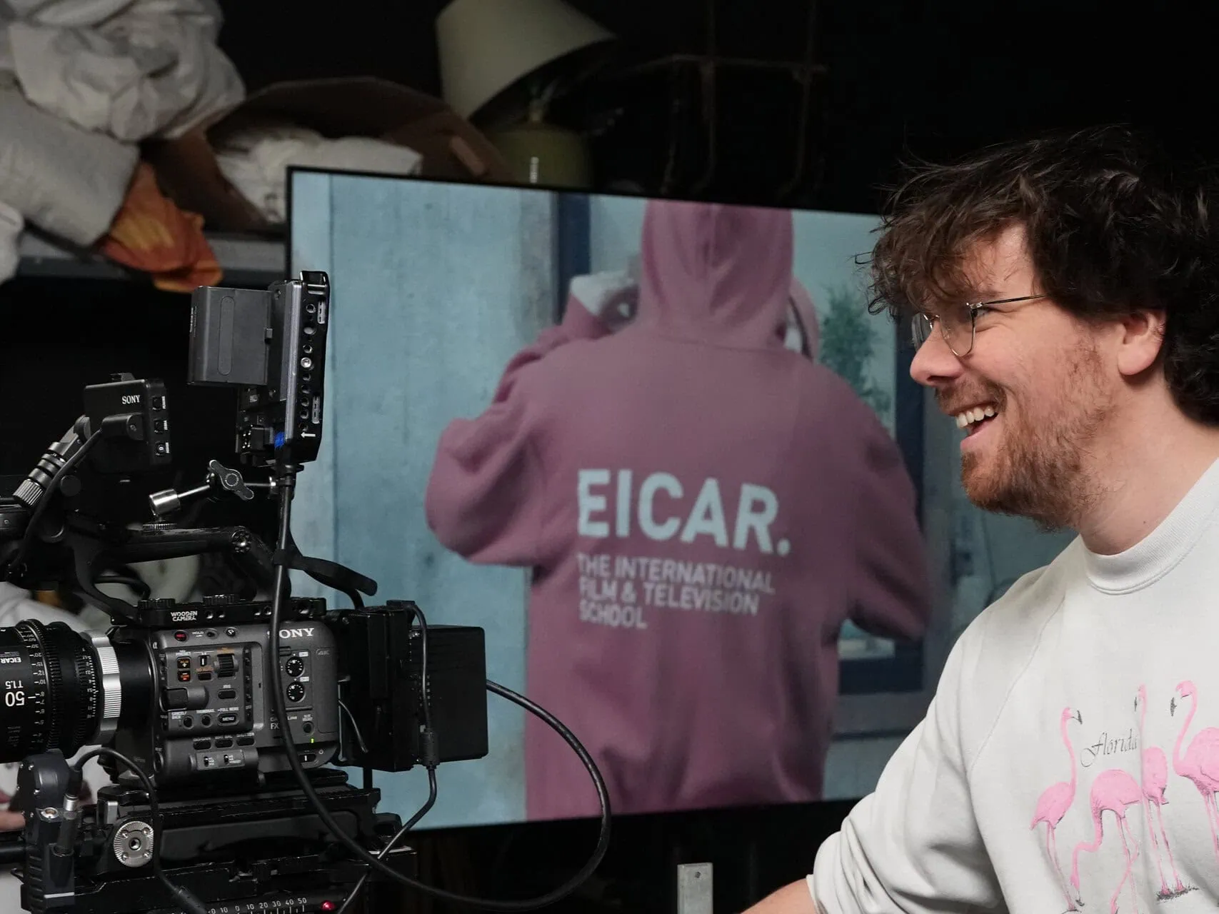 Caméra professionnelle et matériel de studio, homme souriant en tournage.