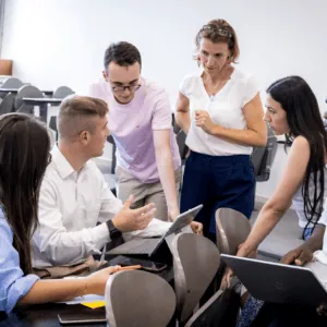 Groupe détudiants en travail collaboratif autour dune tablette en salle de classe moderne.